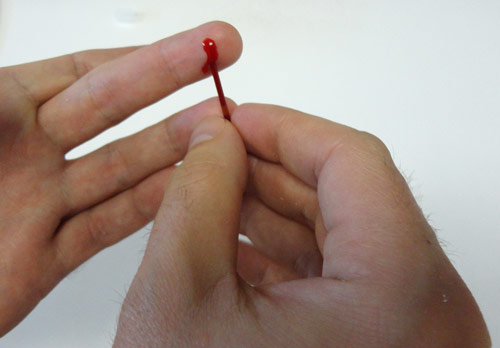 Kapka krve z prstu se nasaje do trubičky...